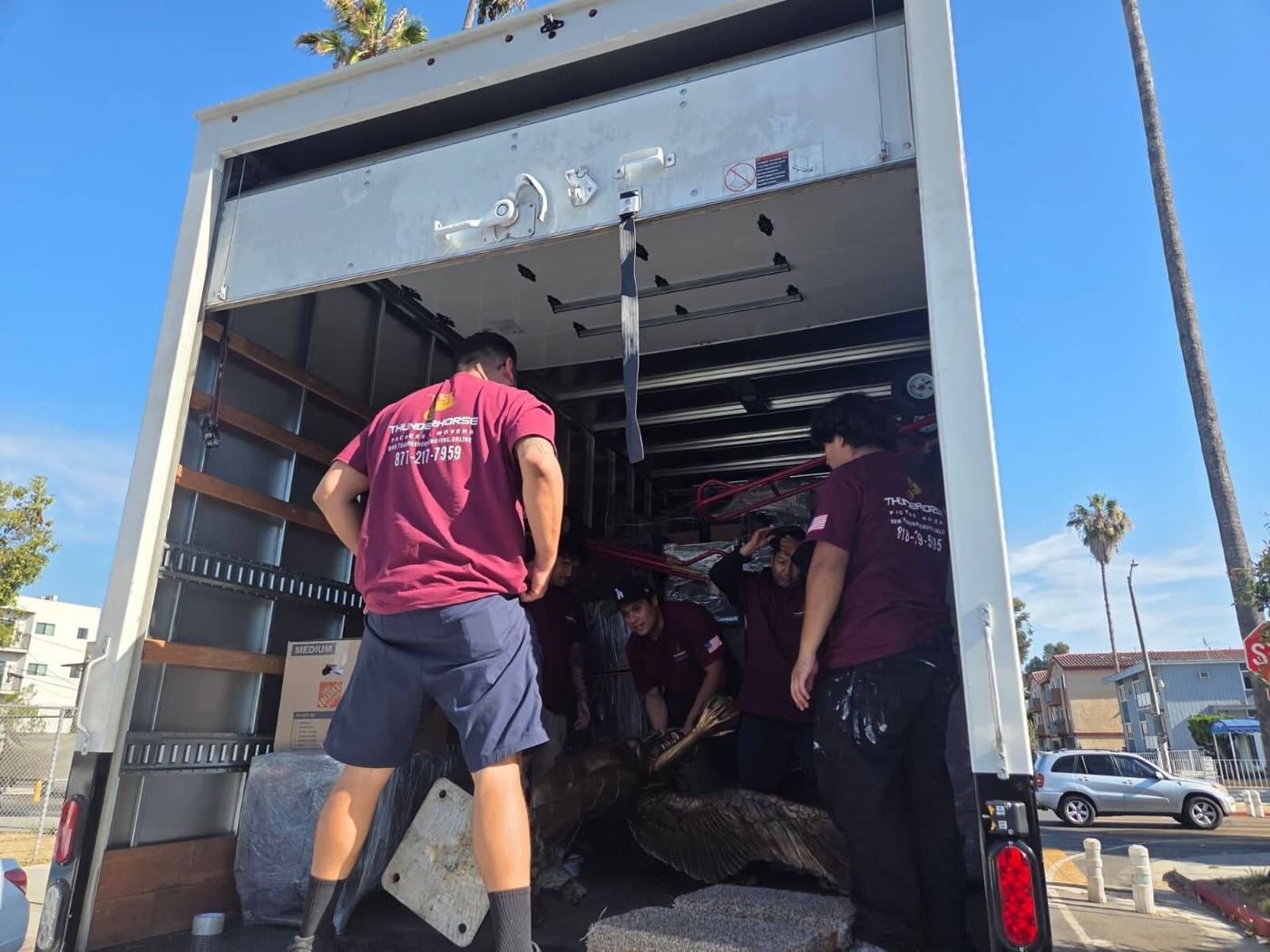 Four Thunderhorse movers loading a truck.